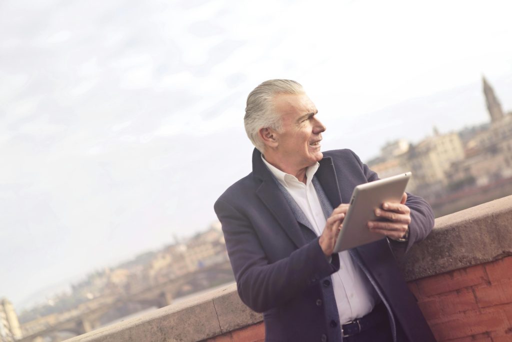 Man In Black Suit Holding A Tablet